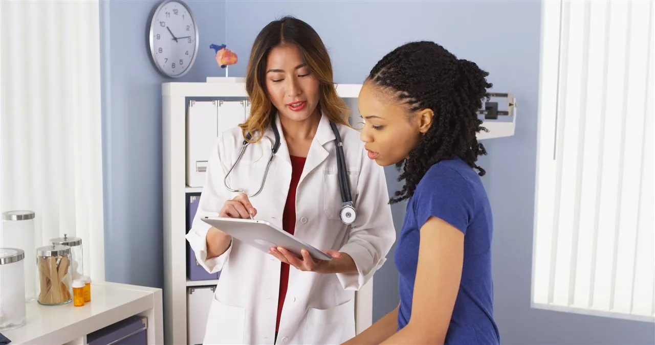 A clinician explaining information to a patient using a tablet
