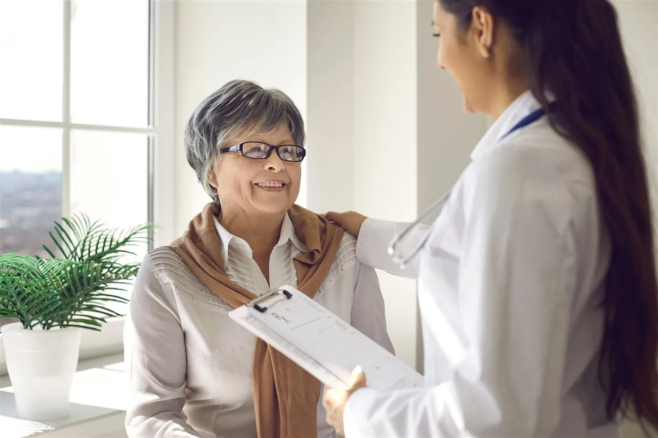A friendly advisor reassuring a smiling older woman
