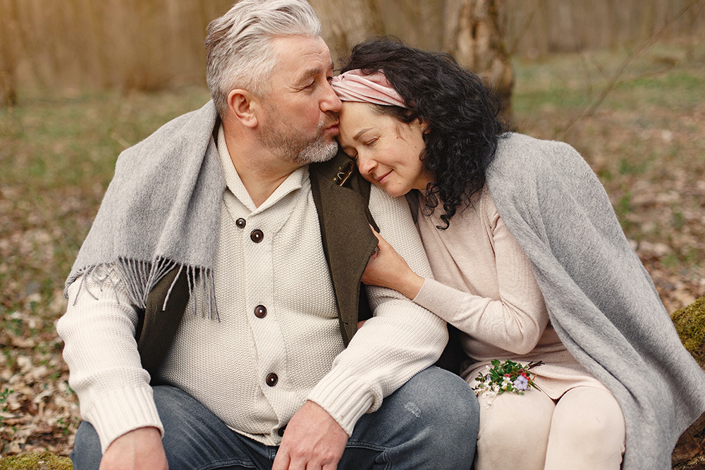 A tender moment between an older couple outdoors